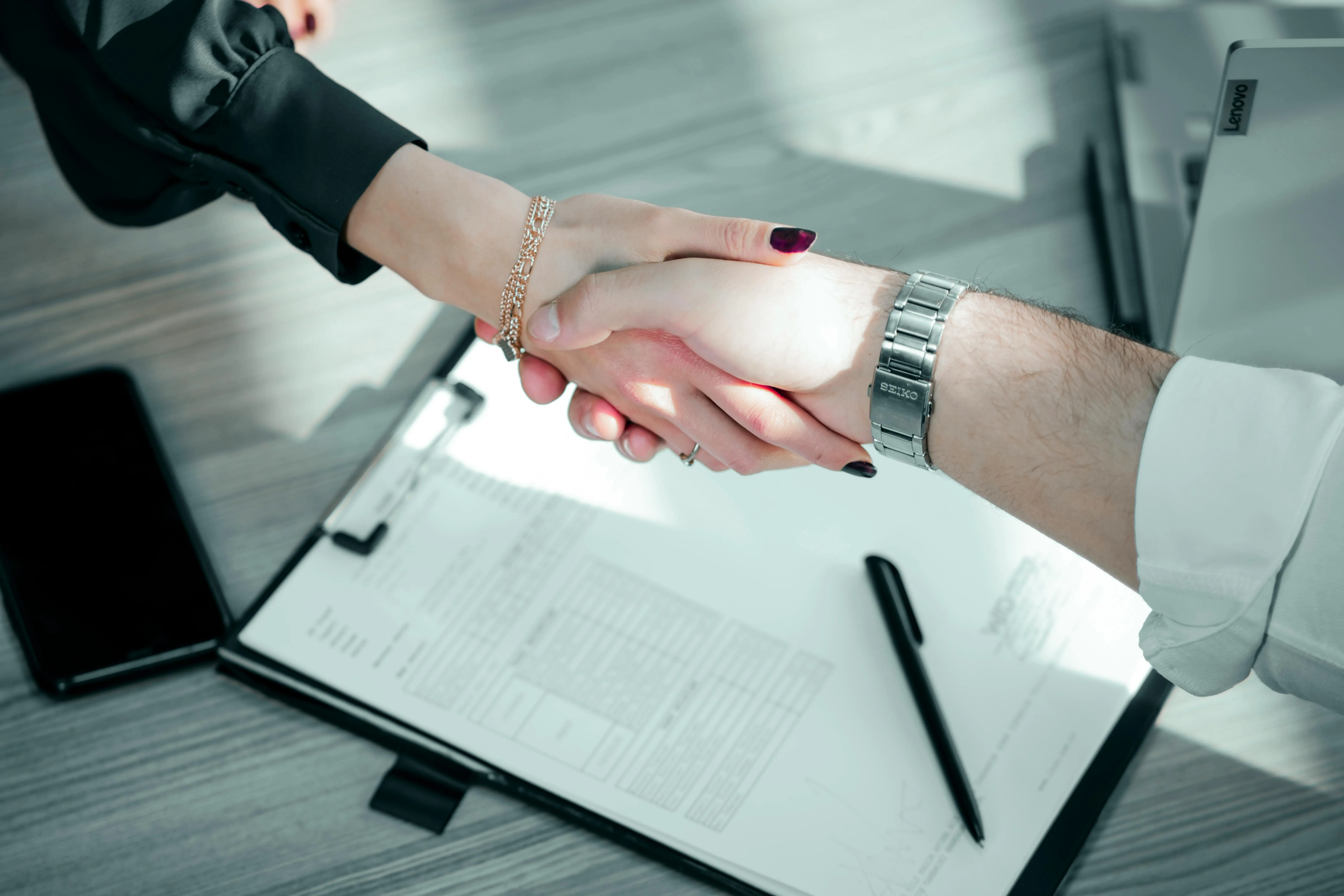 A Dubai business owner shaking hands over a signed VAT engagement letter, having checked the consultant's licence and scope before appointing them