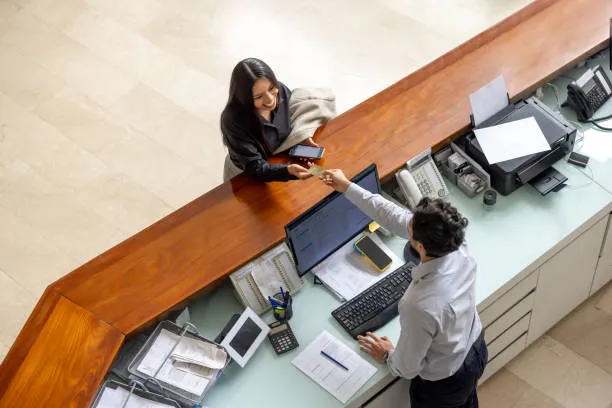 Finance and payroll administrator handling multi-country employee records and statutory filings at a UAE office reception desk