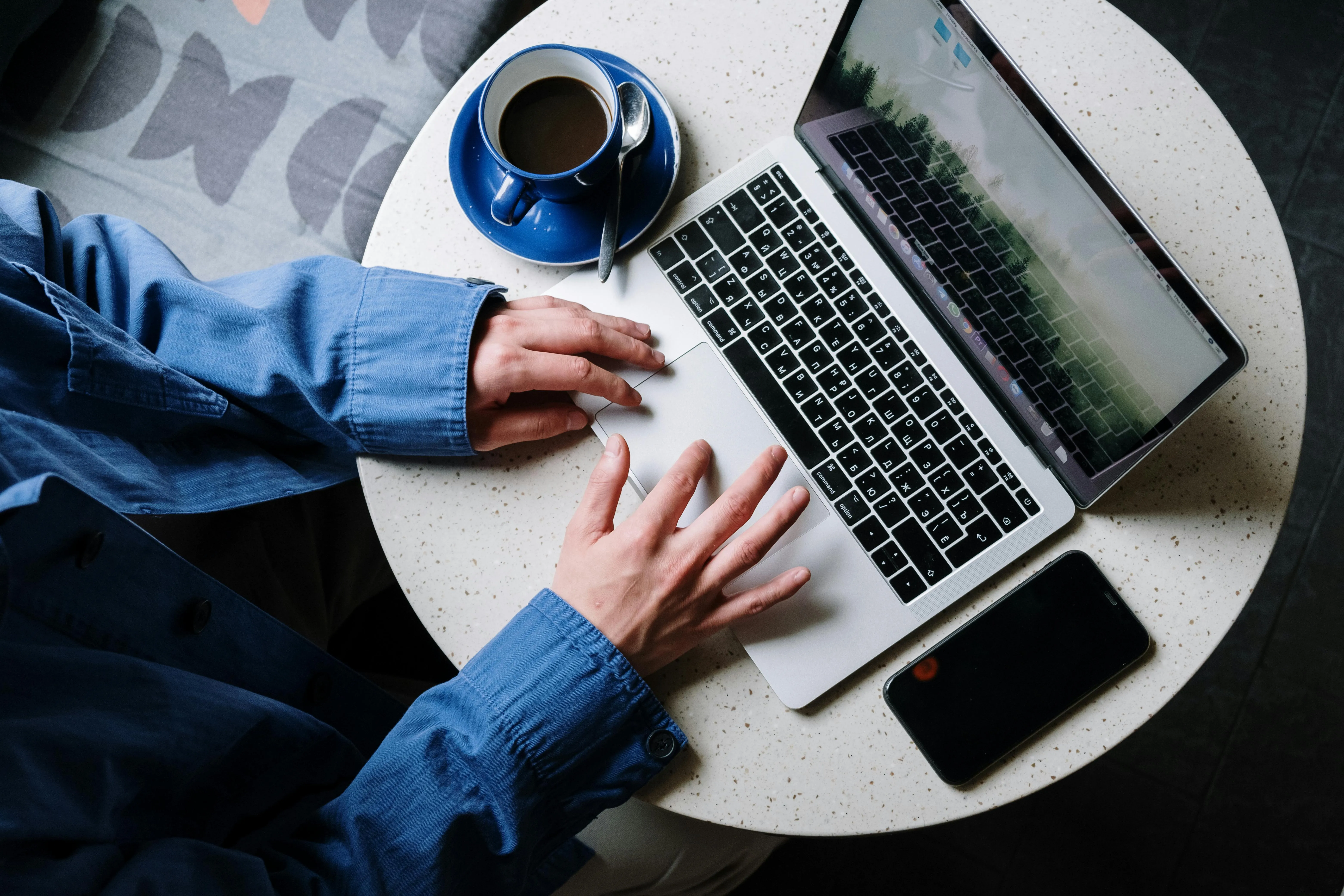 Overhead view of a UAE finance team member working through a monthly bank reconciliation on a laptop, matching the bank statement to the cash book