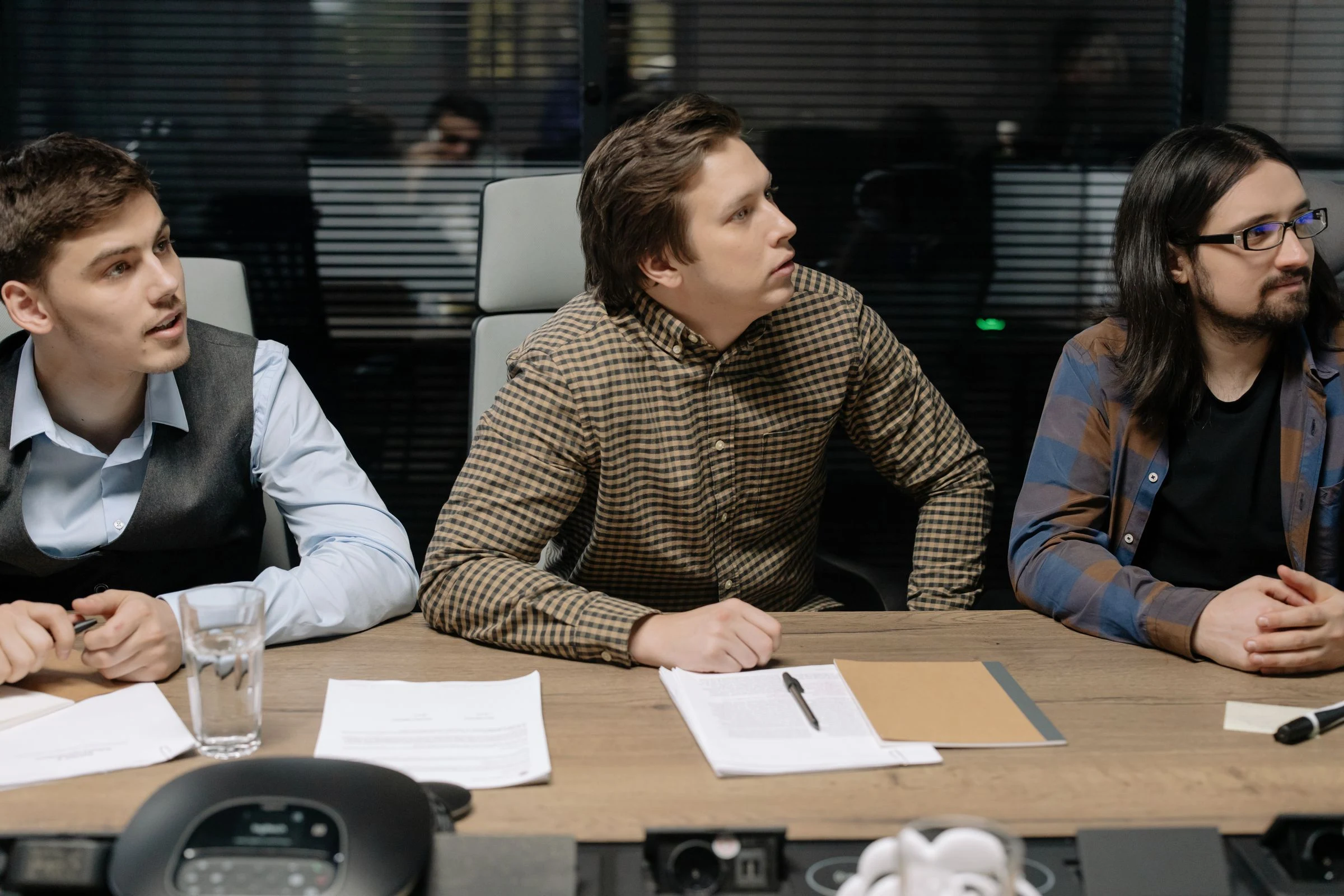 Two advisers comparing printed market remuneration data against a UAE company's payroll while scoping a connected-person salary benchmarking file
