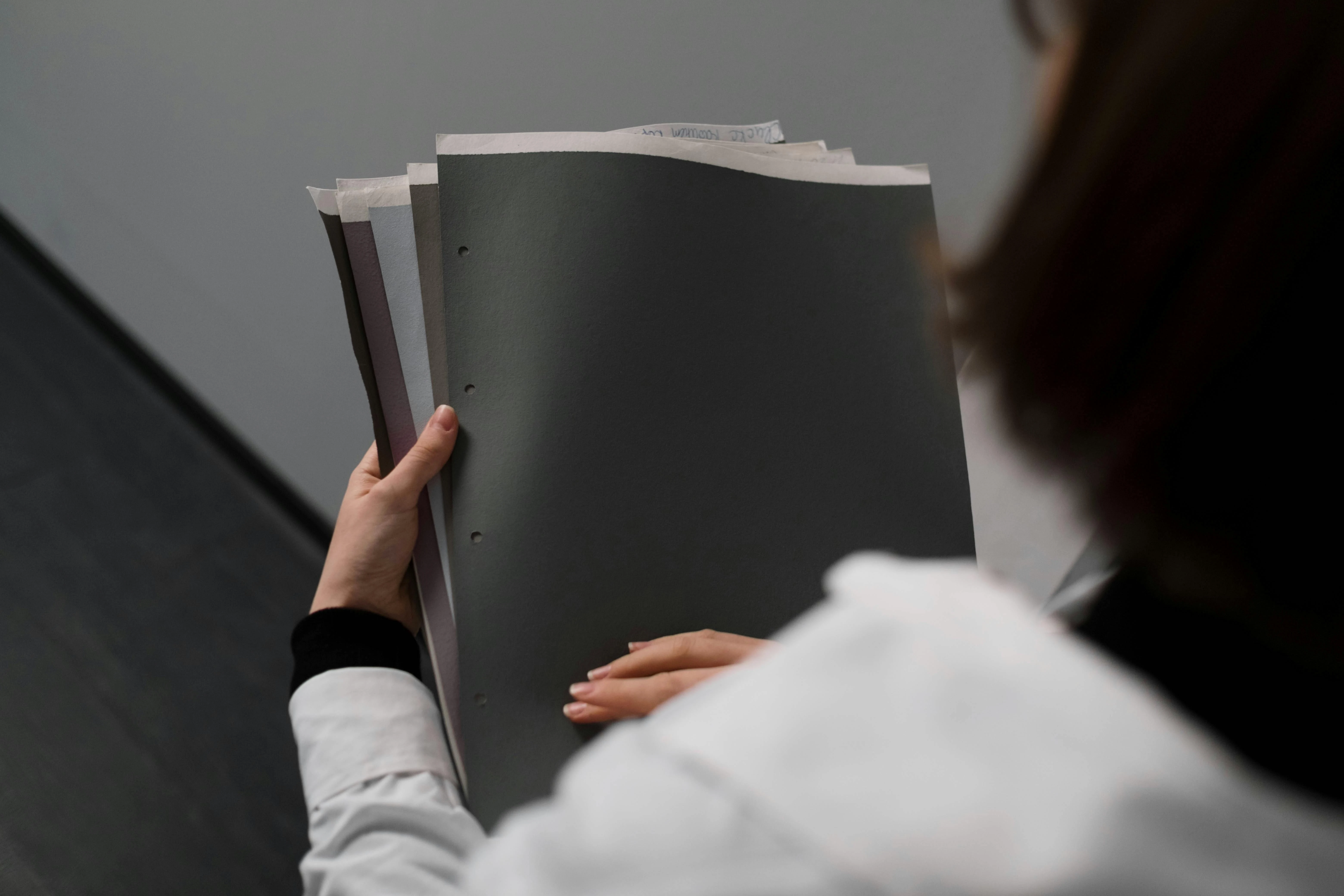 AML compliance services UAE — advisor reviewing a DNFBP KYC file, business risk assessment template and goAML registration checklist at a Dubai office desk